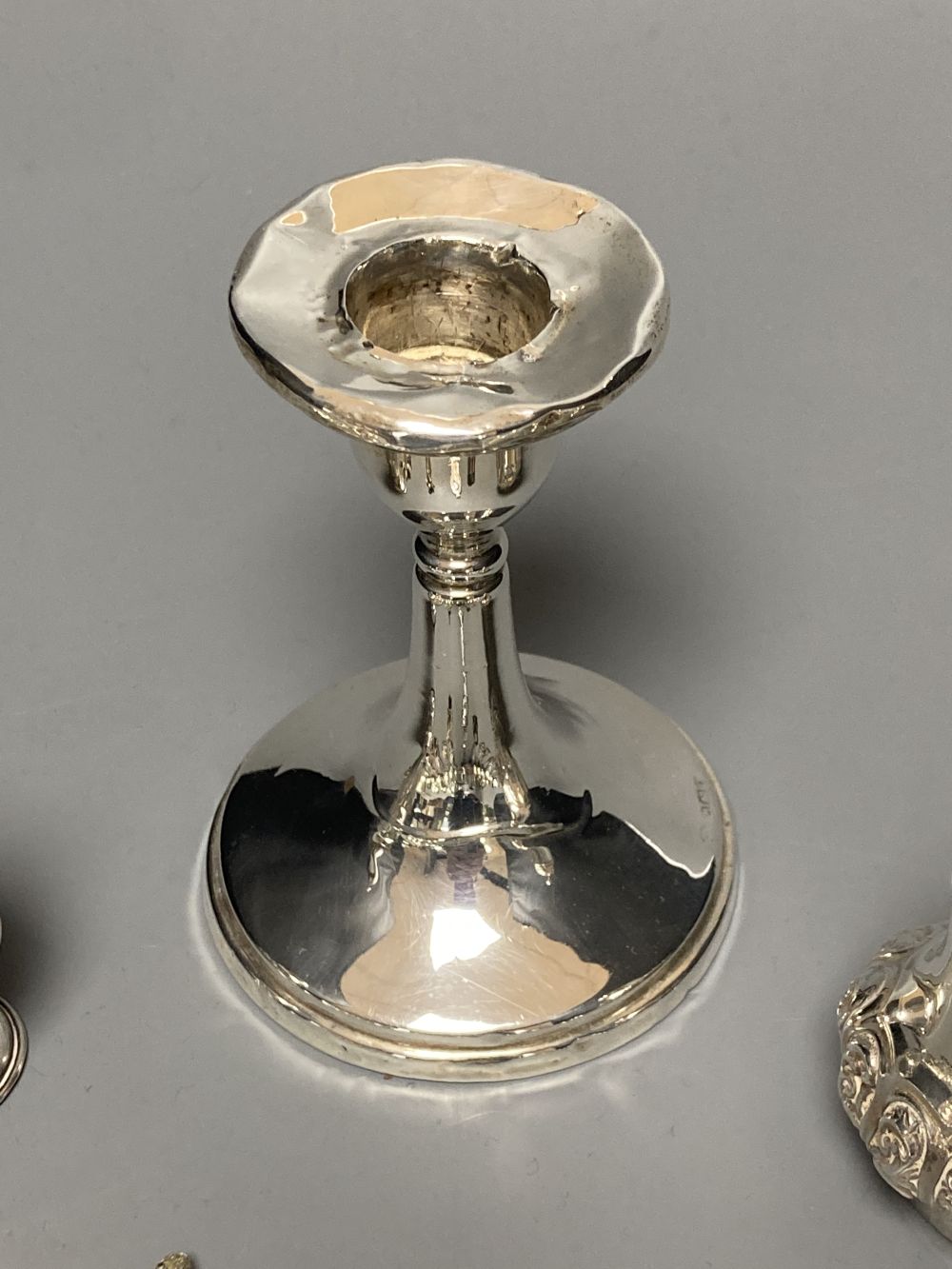 A silver dwarf candlestick, two silver condiments and a group of assorted silver, white metal and plated mainly commemorative spoons,